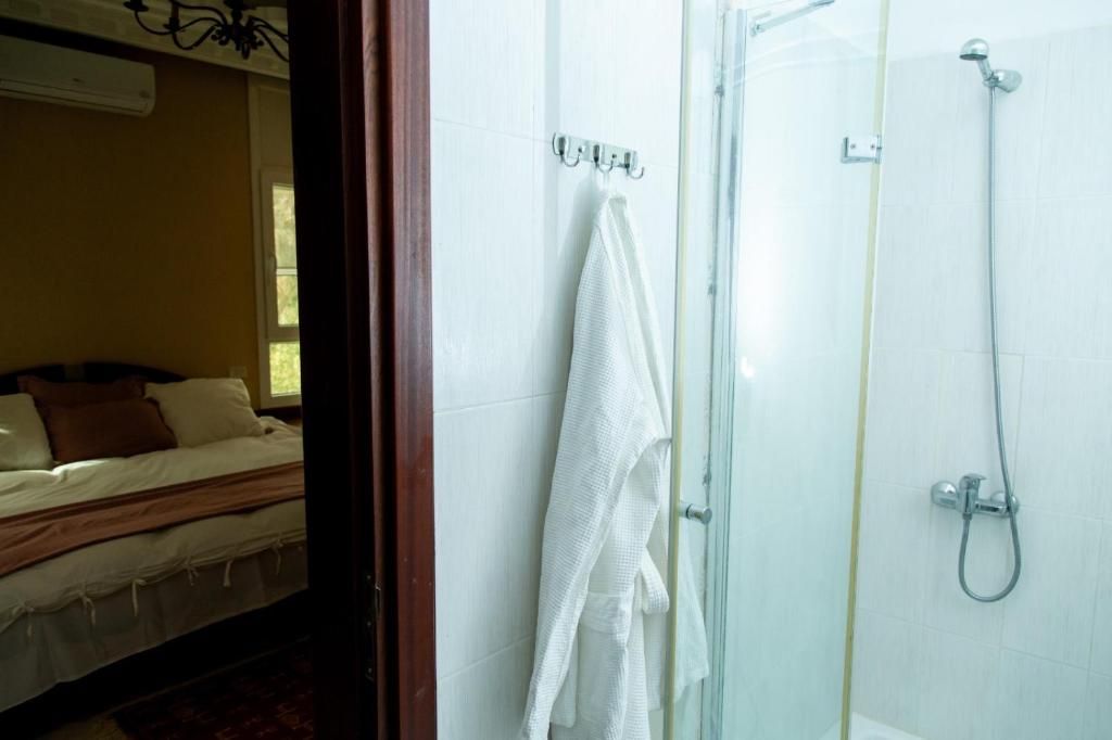 Een hotelkamer met een bed, een douche en een handdoekrek.