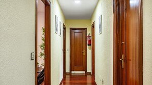 A hallway with wooden doors, a fire extinguisher, and framed pictures on the walls. - Apartment 'Centro Y Mar En Llanes' with Sea View and Wi-Fi (Llanes)