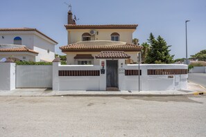 A residential building with a gated entrance, a tiled roof, and a clear sky.