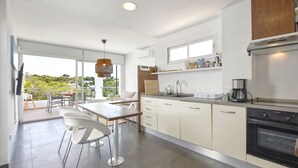 Una cocina moderna con comedor, ventanas amplias y vista a zonas verdes.