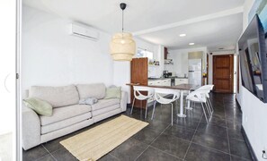 Una cocina moderna con zona de comedor, sofá y alfombra.
