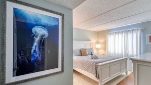 Una camera da letto con un letto, comodino, lampada e tende.