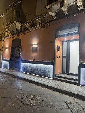 A building with a reception area, a door, and a manhole cover on the sidewalk.
