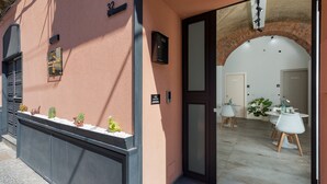 A hotel entrance with a modern design, including a reception area with a counter and seating, and a visible room number. - Neg Naumachia Rooms - Triple Room 3 (Catania)