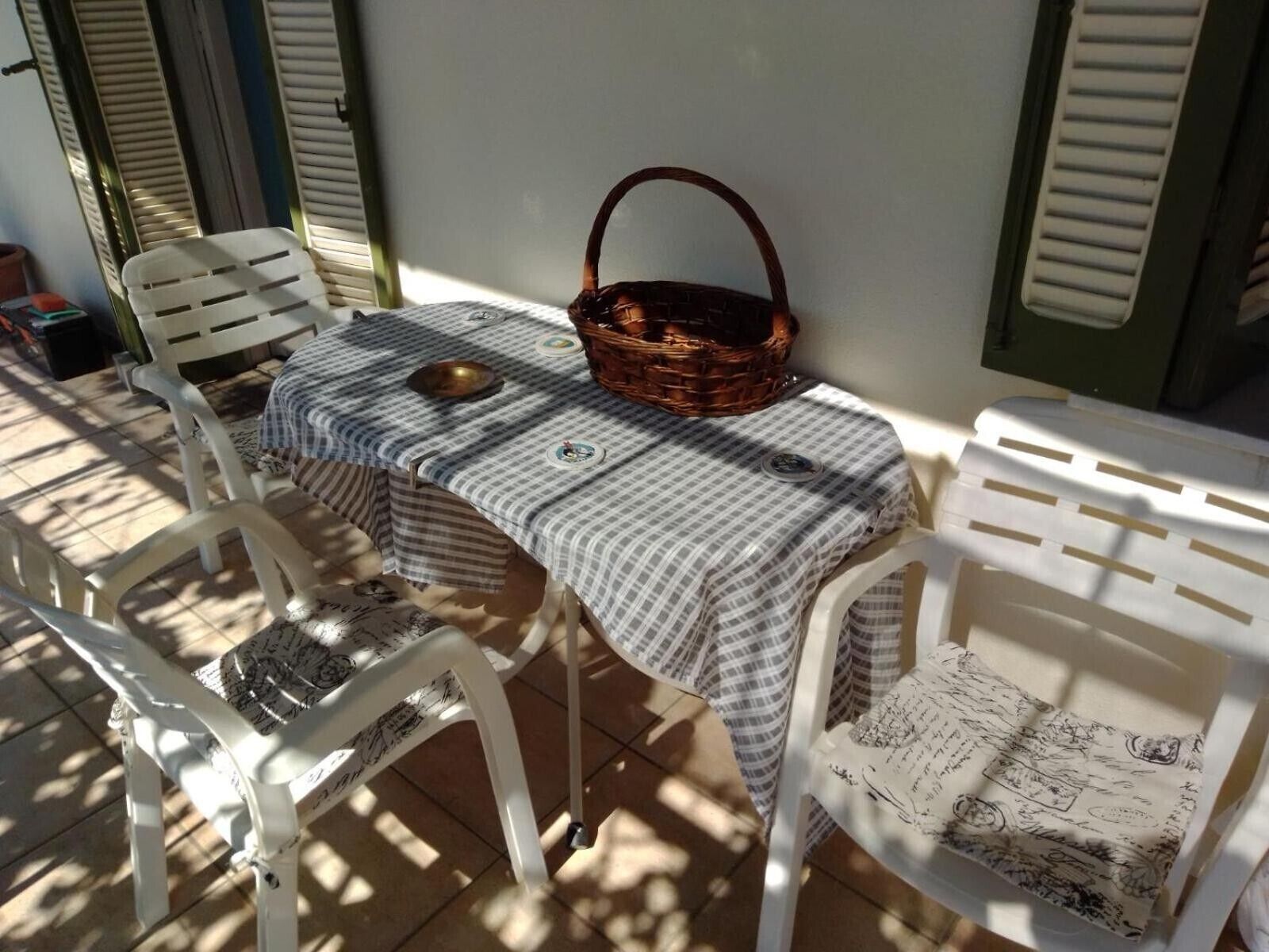 Una mesa con mantel a cuadros, una cesta de mimbre y un cuenco de latón.
