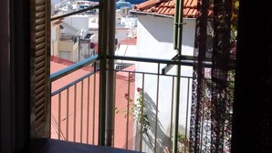 Janela com vista para um horizonte costeiro, incluindo edifícios e um grande navio de cruzeiro.