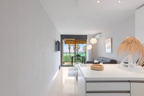 A modern interior with a kitchen area, a dining table, and a view of the outdoors. - London Cannes, Sea View (Cannes)