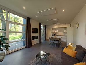 Ein modernes Wohnzimmer mit einer Couch, einem Couchtisch und einem Essbereich mit Tisch und Stühlen.