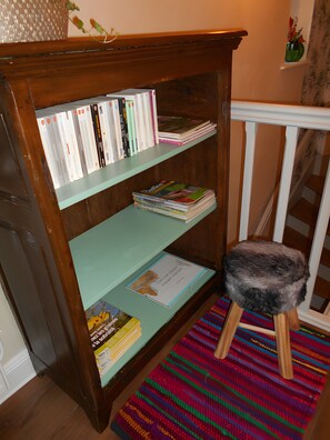 Ein Bücherregal aus Holz mit Büchern und einem gerahmten Zertifikat.