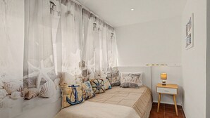 Une chambre à coucher comprenant un lit, une table de chevet, une lampe et une étagère murale agrémentée d’objets décoratifs.