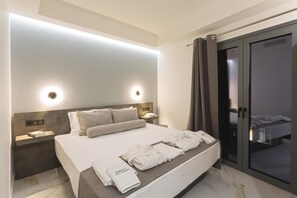 Una habitación de hotel moderna con una cama grande, mesitas de noche y una puerta corrediza de cristal a un balcón.