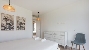 Ein Schlafzimmer mit einem großen Bett, einem Schminktisch, einem Sessel und zwei Wandlampen.