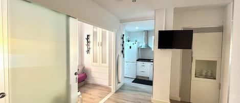A modern apartment with a kitchen, a living area, and a bedroom.