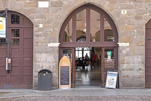 A stone building with a large arched entrance, a signboard, and a metal door. - Room 'Stanza 2' with Wi-Fi and Air Conditioning (Bergamo)