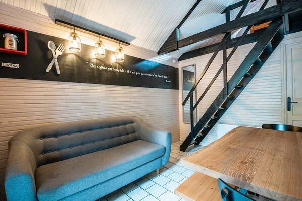 Un intérieur moderne avec un canapé, une table en bois et un escalier.