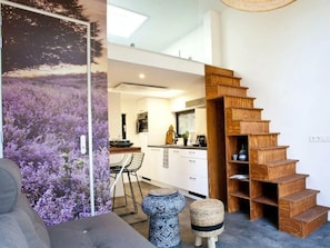Ein modernes Interieur mit einer Holztreppe, einer Küchenzeile und einem Essbereich.
