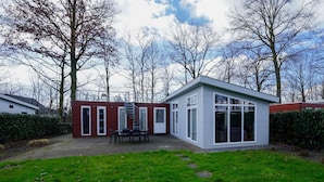 Ett modernt hus med en uteplats, en trappa och en trädgård.