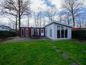 Ein modernes Haus mit Terrasse, Treppe und Garten.