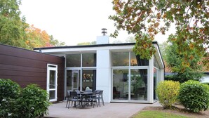 Ett modernt hus med en uteplats, ett matområde och ett garage.