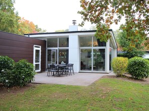 Ein modernes Haus mit Terrasse, Essbereich und Garage.
