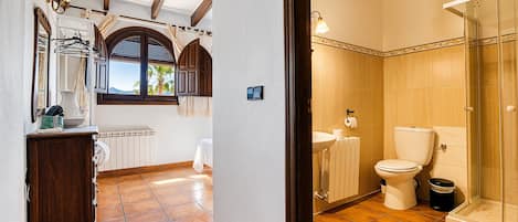 A bathroom with a toilet, sink, and shower.