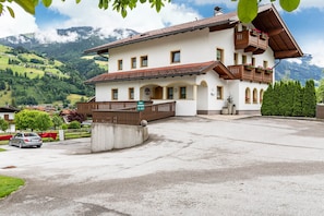 Un bâtiment à deux étages doté d’un balcon, d’une enseigne indiquant qu’il s’agit d’un restaurant, et offrant une vue sur des montagnes en arrière-plan.