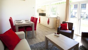 A modern living room with a dining area, a kitchen, and a view of the outside. - Holiday Home in Breskens With Terrace (Breskens)