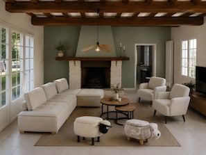Een woonkamer met een hoekbank, twee fauteuils, een open haard, een televisie en een plafondventilator.