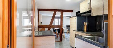 Een moderne keuken met houten kastjes, een zwart aanrecht en een roestvrijstalen spoelbak.
