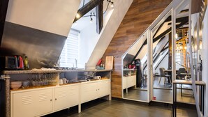 A modern kitchen with a wooden ceiling, a built-in counter, and a large window. - Loft Bariga Apartment – Between Vineyards and Ramparts (Bergheim)