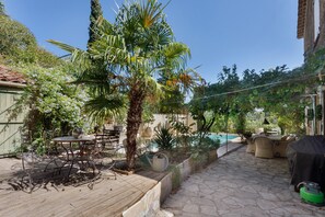A patio area with outdoor furniture, a palm tree, and a swimming pool. - Holiday Home 'L'écrin Provençal' with Private Pool, Private Terrace and Wi-Fi (Callian)