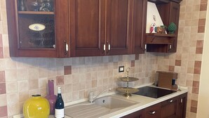 Una cucina con mobili in legno, un lavello e un piano di lavoro.