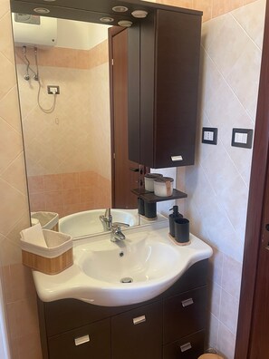 A bathroom with a white sink, a mirror, a dark wooden cabinet, and a towel rack. - Villa Mario – Private Hot Tub and Mountain View in Rosciano (Rosciano)