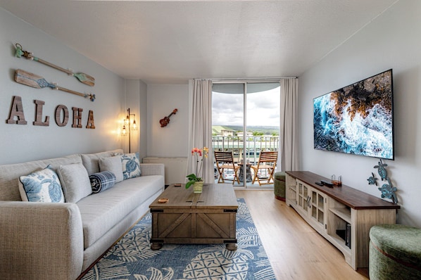 A living room with a sofa, coffee table, and a view through a glass door.
