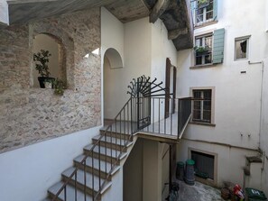 Ein mehrgeschossiges Gebäude mit Treppe, Steinmauern und Balkonen.