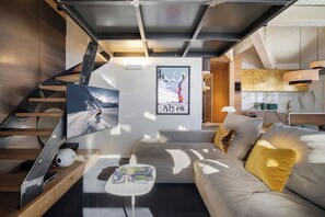 A modern living room with a sofa, coffee table, and a framed picture on the wall.