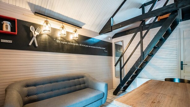 Ein modernes Interieur mit einer Couch, einem Holztisch und einer Treppe.