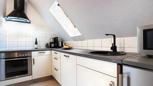 A modern kitchen with a built-in oven, a coffee maker, and a sink.