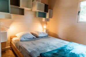 Une chambre à coucher comprenant un lit, des tables de chevet et des étagères intégrées.