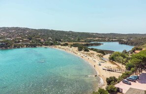 A coastal area with a beach, clear water, and a hilly background. - Villa La Torretta (Aldia Bianca)