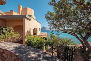 A coastal property with a stone pathway, a tree, and a view of the sea. - Villa La Torretta (Aldia Bianca)