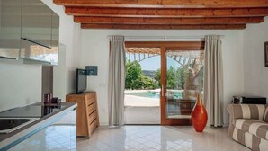 Eine moderne Küche mit einer Glasinsel, Holzboden und Blick auf einen Pool.
