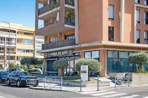 Un immeuble à plusieurs étages abritant un restaurant appelé « Casa Di Giù » au rez-de-chaussée, avec une terrasse et une enseigne.