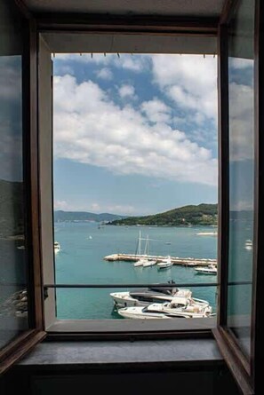 Blick vom Balkon auf einen klaren Himmel, ein Gewässer und Boote im Hafen.