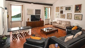 Un salon avec un canapé, une table basse et des œuvres d’art accrochées au mur.