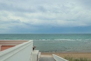 Blick auf das Meer vom Balkon bei blauem Himmel.