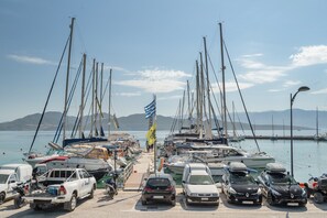 A marina with boats, cars, and a clear sky. - Room 'Quadruple  401' with Sea View, Wi-Fi and Air Conditioning (Nikiana)