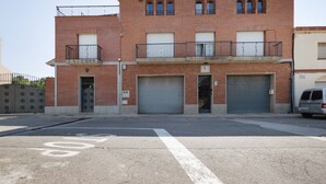 Un immeuble à plusieurs étages, doté d’une façade en briques, de deux balcons et de deux portes de garage.