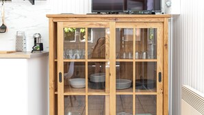 Un buffet en bois doté de portes en verre, dans lequel sont rangées des assiettes et des bols empilés.