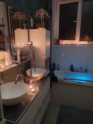 Et stilfuldt badeværelse med to håndvaske, et badekar og et vindue.